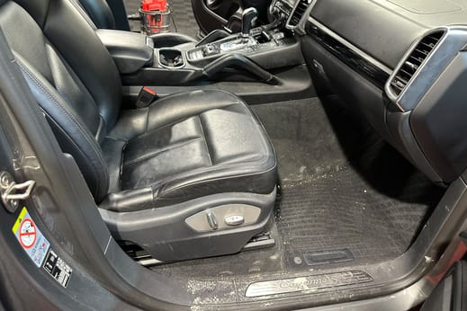 Fahrerseite eines SUV vor der Innenreinigung: Schmutz auf Einstiegsleiste, Fussmatte und Boden.